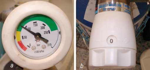 Fig 5: Le débitmètre (a)  indique  à la fois  le taux de remplissage de la bouteille et de la pression résiduelle. La zone verte est la zone de sécurité  de  travail.  Lorsque  l’aiguille  est  dans  la   zone  jaune, l’inhalation est encore possible. Le renouvellement de la  bouteille doit être prévu.  Dans la zone rouge,  l’inhalation  est interdite  en raison du risque d’inhalation d’un mélange non homogène. Le débit (l/min) se règle facilement grâce au bouton blanc (b) situé juste sous le débitmètre.